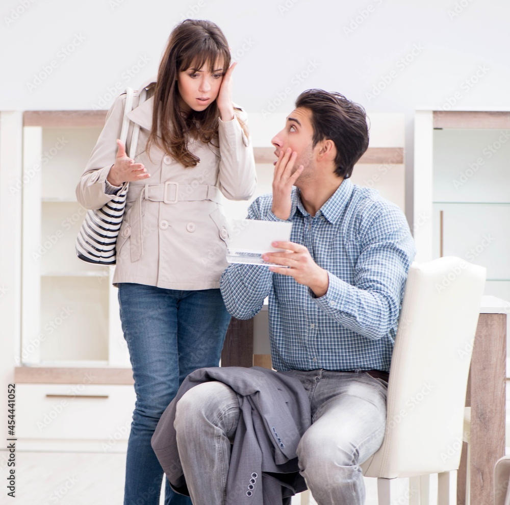 Young couple disappointed with price in furniture store