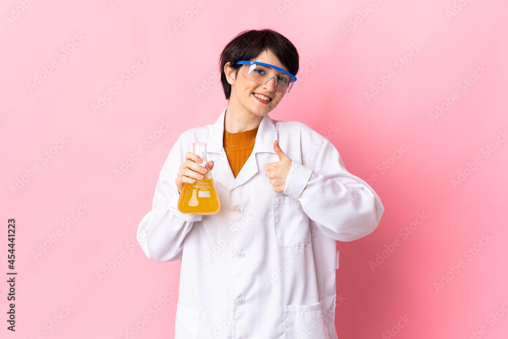 Young scientific woman isolated on pink background giving a thumbs up gesture