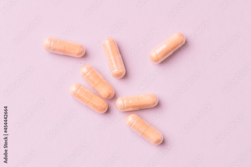 Goji Berry (Wolfberry) capsules. Immune system support. Dietary supplement on pink paper background. Top view. Close up. Goji Berry (Wolfberry) capsules. Immune system support. Dietary supplement on pink paper background. Top view. Close up.