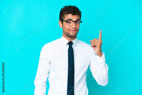 Young business Brazilian man isolated on blue background pointing with the index finger a great idea