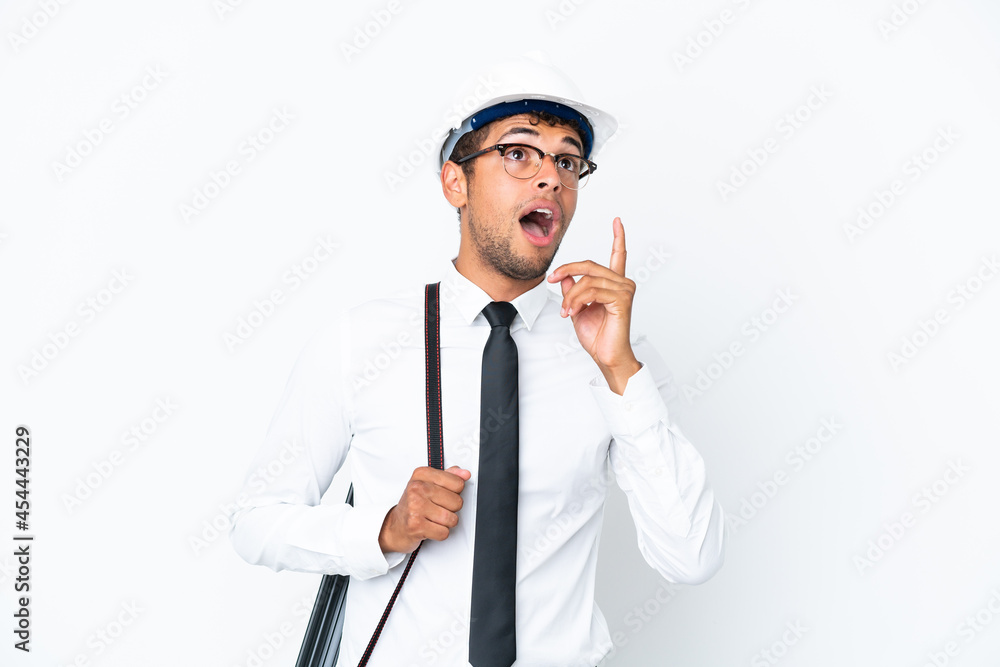 Architect brazilian man with helmet and holding blueprints thinking an idea pointing the finger up Architect brazilian man with helmet and holding blueprints thinking an idea pointing the finger up