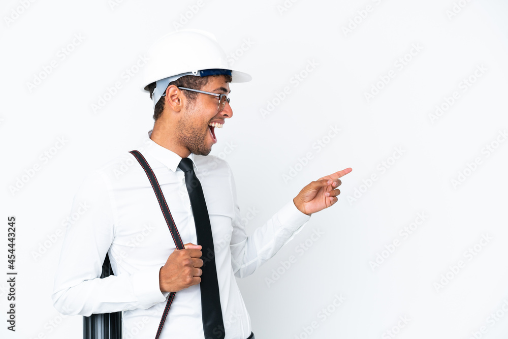 Architect brazilian man with helmet and holding blueprints pointing finger to the side and presenting a product Architect brazilian man with helmet and holding blueprints pointing finger to the side and presenting a product