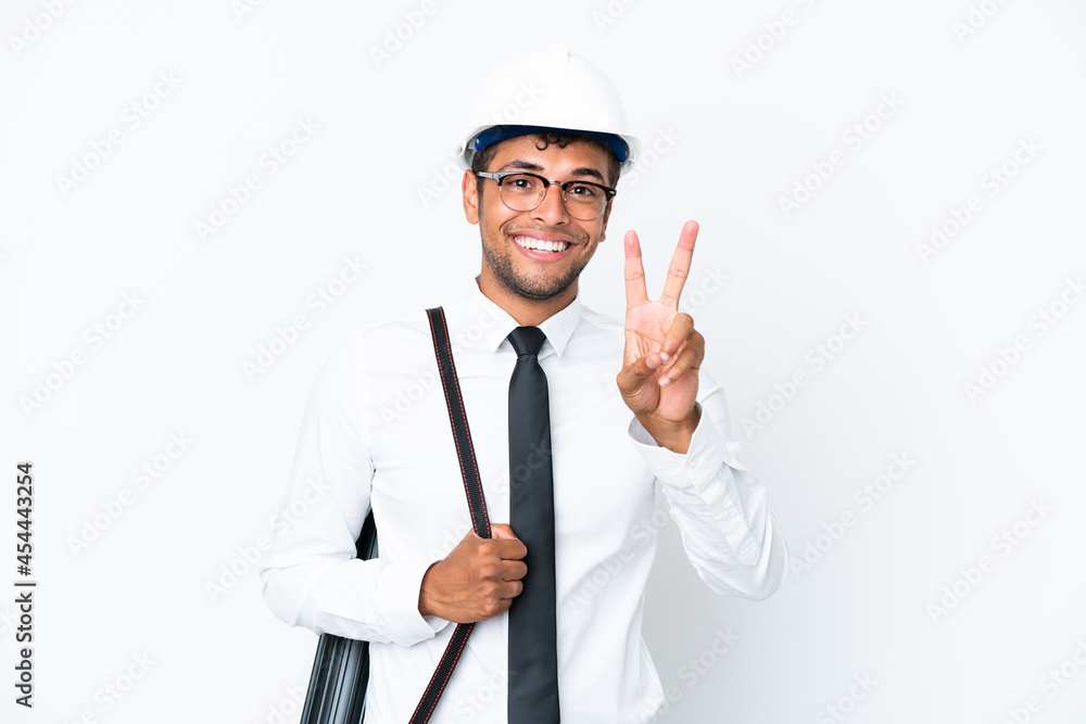 Architect brazilian man with helmet and holding blueprints smiling and showing victory sign Architect brazilian man with helmet and holding blueprints smiling and showing victory sign