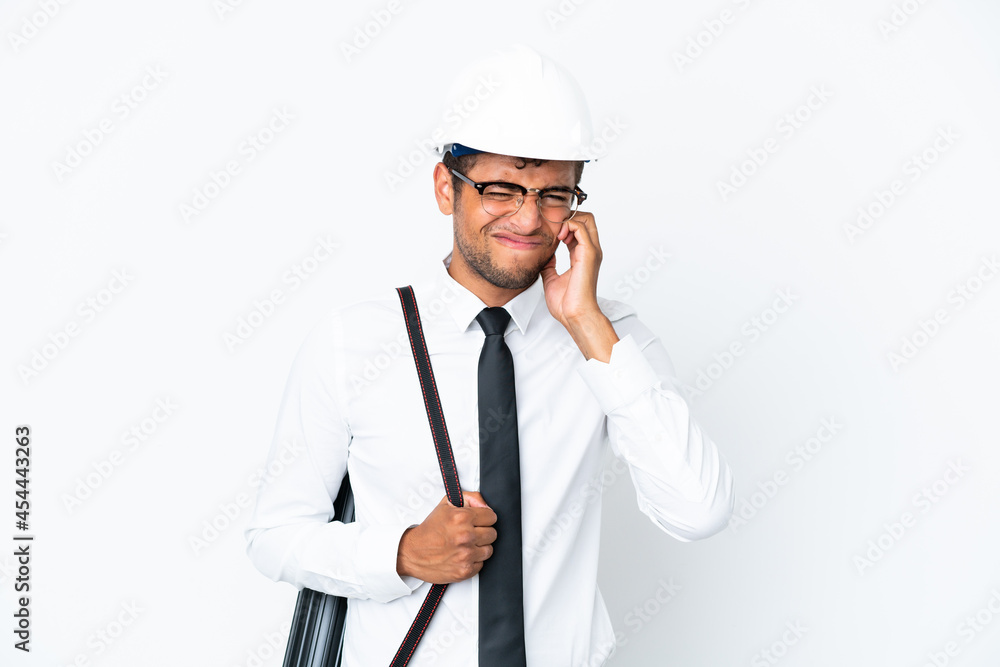 Architect brazilian man with helmet and holding blueprints frustrated and covering ears Architect brazilian man with helmet and holding blueprints frustrated and covering ears