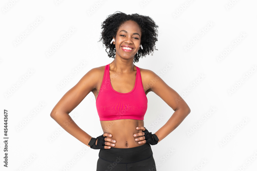 Young African American woman isolated on white background posing with arms at hip and smiling
