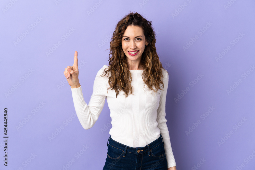 Young caucasian woman isolated on purple background showing and lifting a finger in sign of the best Young caucasian woman isolated on purple background showing and lifting a finger in sign of the best
