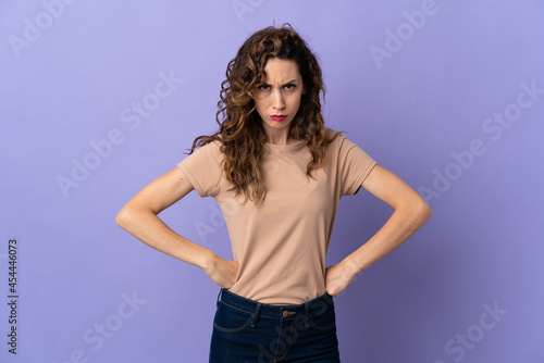 Young caucasian woman isolated on purple background angry