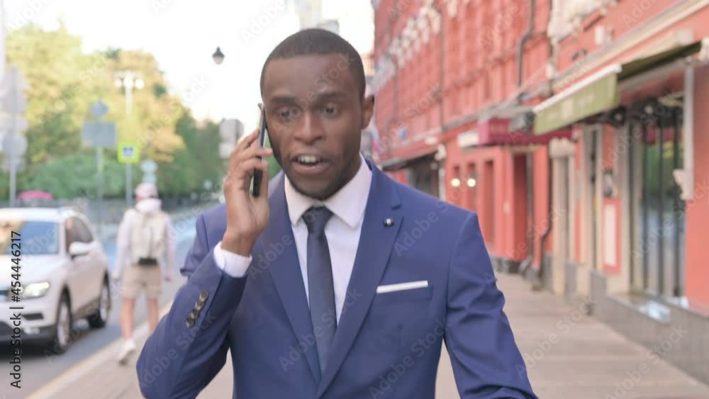 Walking African Businessman Getting Angry on Phone Call Walking African Businessman Getting Angry on Phone Call