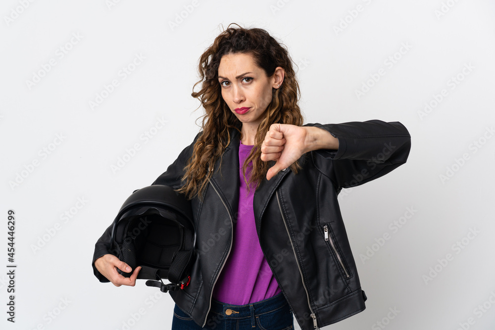 Fototapeta premium Young caucasian woman holding a motorcycle helmet showing thumb down with negative expression