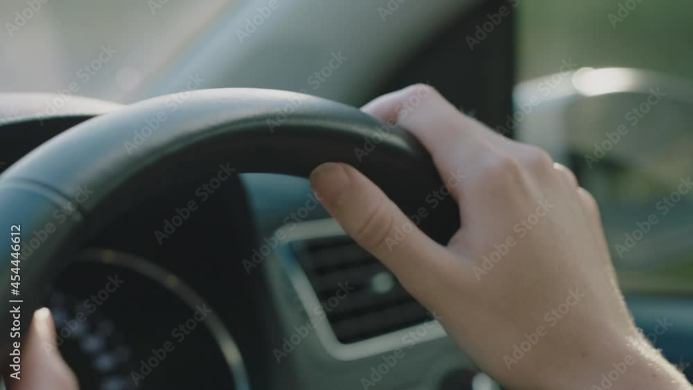 woman driver hands on steering wheel driving car in city on the road at rush hour travelling to destination at sunset woman driver hands on steering wheel driving car in city on the road at rush hour travelling to destination at sunset