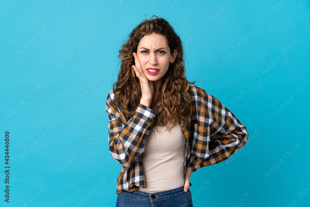 Young caucasian woman isolated on blue background with toothache Young caucasian woman isolated on blue background with toothache