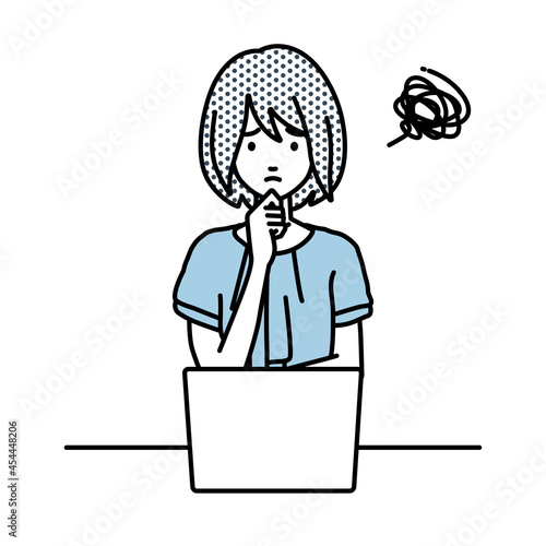 デスクで座ってPCを開いて困っているオフィスカジュアルの女性