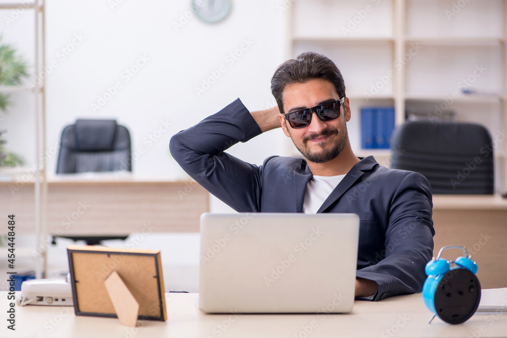 Young handsome employee in time management concept Young handsome employee in time management concept