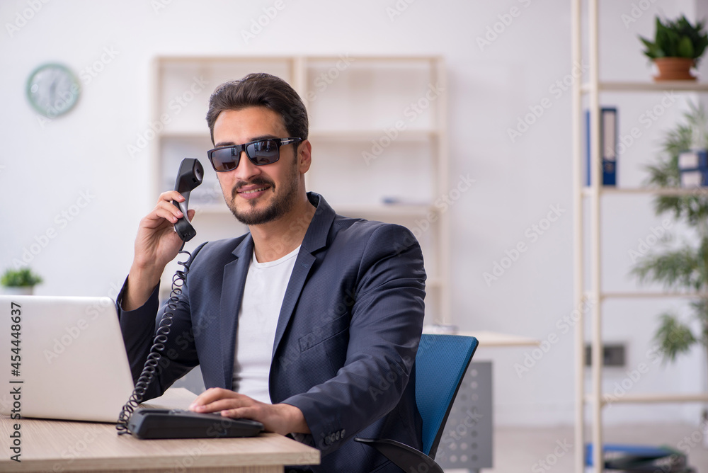 Young handsome employee working in the office Young handsome employee working in the office