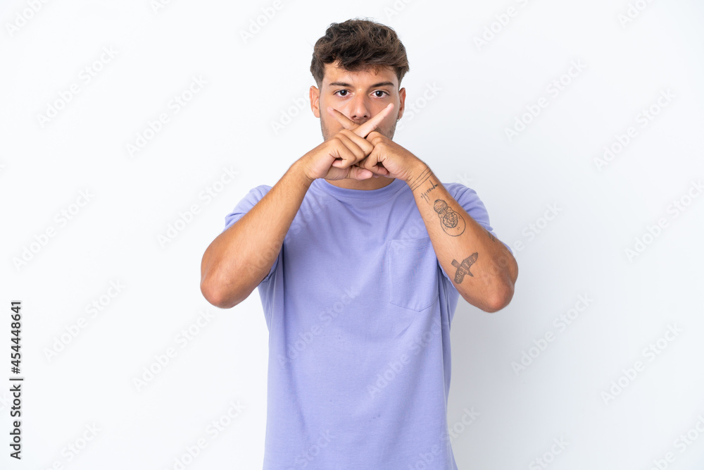 Young caucasian handsome man isolated on white background showing a sign of silence gesture Young caucasian handsome man isolated on white background showing a sign of silence gesture