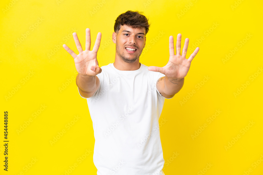 Young caucasian handsome man isolated on yellow background counting nine with fingers Young caucasian handsome man isolated on yellow background counting nine with fingers