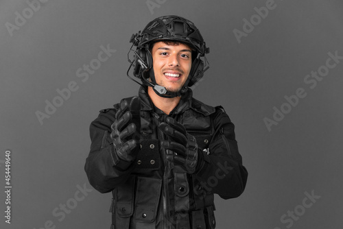 SWAT caucasian man isolated on grey background applauding after presentation in a conference © luismolinero