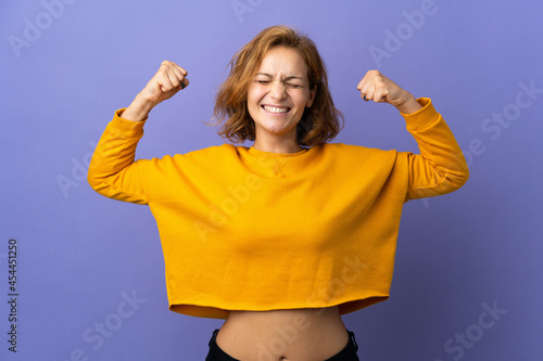 Young Georgian woman isolated on purple background doing strong gesture