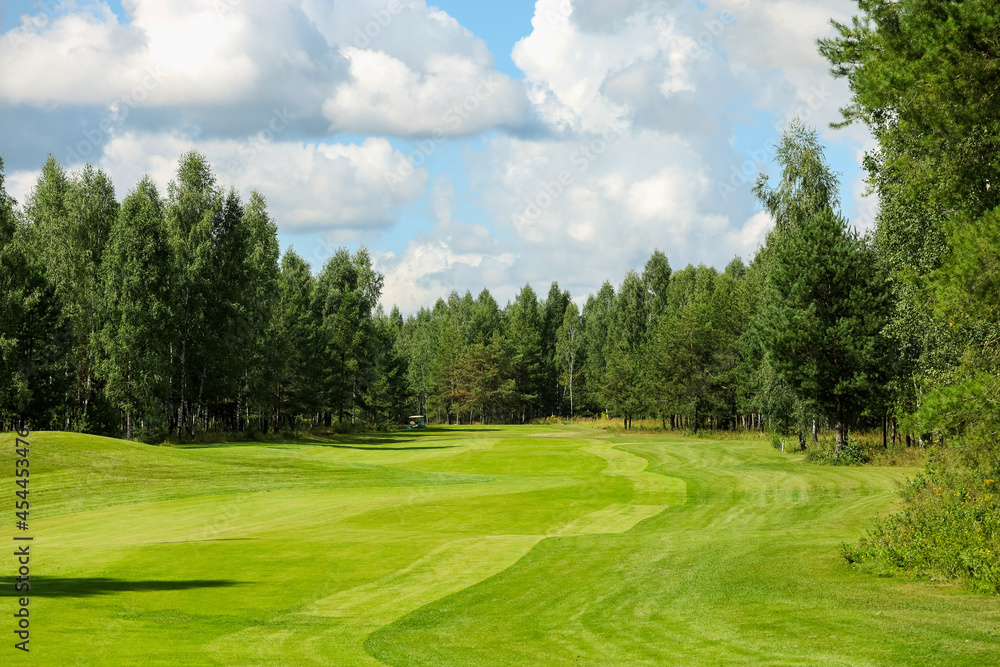 Golf course, landscape, green grass on the background of the forest and a bright sky with clouds. High quality photo Golf course, landscape, green grass on the background of the forest and a bright sky with clouds. High quality photo