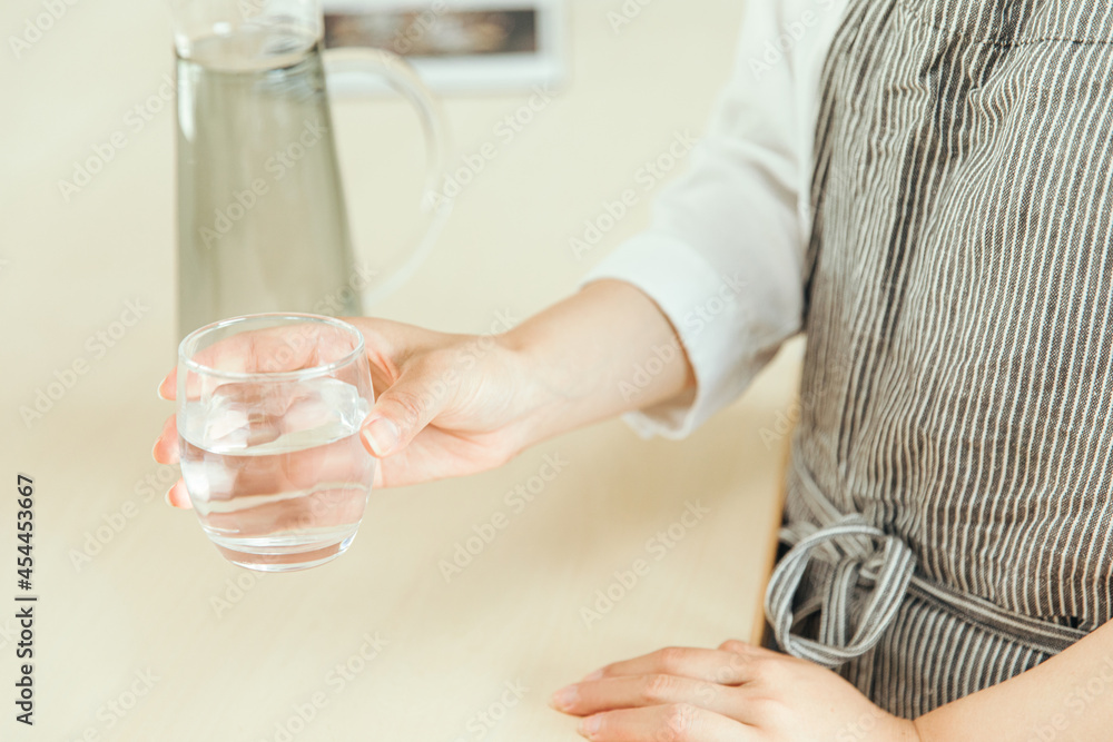 キッチンで透明なグラスを持つ手元　Kitchen cup hand