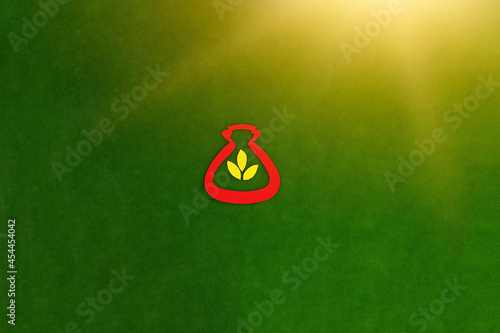 Obraz na płótnie The bag is red, three yellow leaves, meaning gold on a green background. The concept of Financial savings. Investment of funds. w salonie
