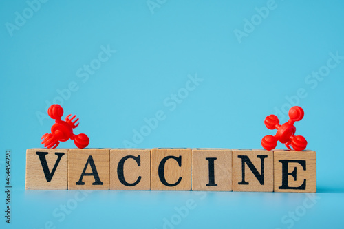 red virus with Wooden cubes with words ''vaccine