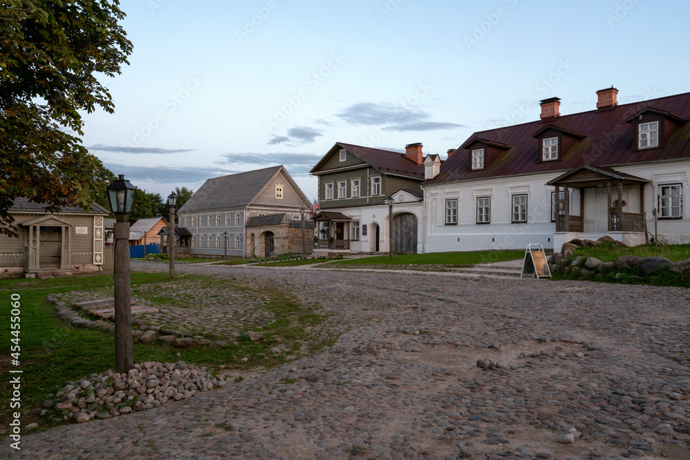 View of the main street of Izborsk Pechorskaya Street with old traditional merchant estates and a paved road on a early summer morning, Izborsk, Pskov region, Russia