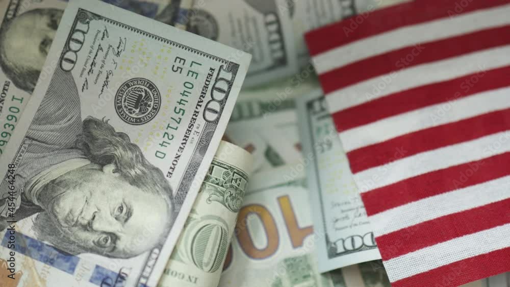 USD money hundred dollars bills banknotes and USA American flag on a top background. Independence Day life finances global economy concept USD money hundred dollars bills banknotes and USA American flag on a top background. Independence Day life finances global economy concept