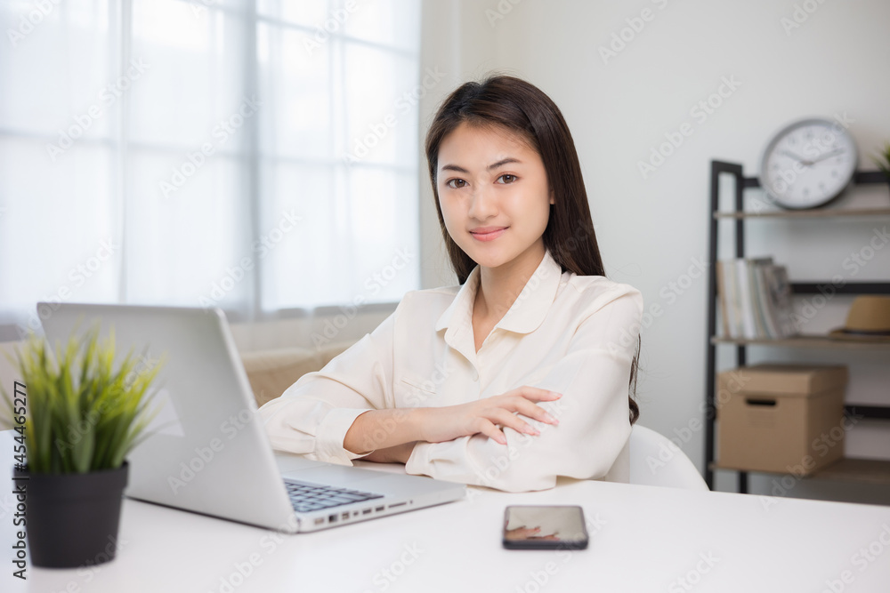 Young asian beautiful business woman working with laptop sitting at home. Smiling charming happy young female doing homework meeting conference with team at home. Young asian beautiful business woman working with laptop sitting at home. Smiling charming happy young female doing homework meeting conference with team at home.