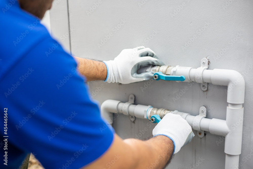 Male Plumber worker installation pipe system hand holding the water tap faucet. Plumbing checking service and repair. Male Plumber worker installation pipe system hand holding the water tap faucet. Plumbing checking service and repair.