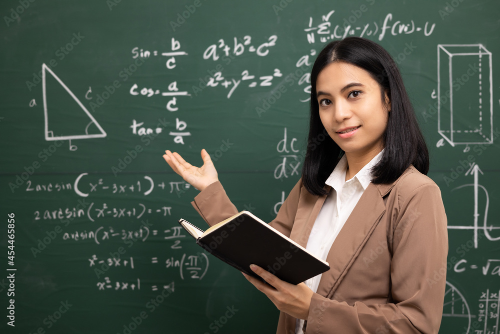 Young asian teacher woman teaching holding book and video conference with student looking camera. Female teacher training the mathematics in classroom blackboard from online course. Young asian teacher woman teaching holding book and video conference with student looking camera. Female teacher training the mathematics in classroom blackboard from online course.