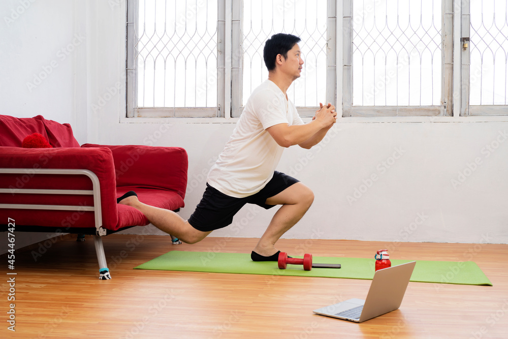 Fototapeta premium smiling indian man with fitness tracker exercising and doing squats at home