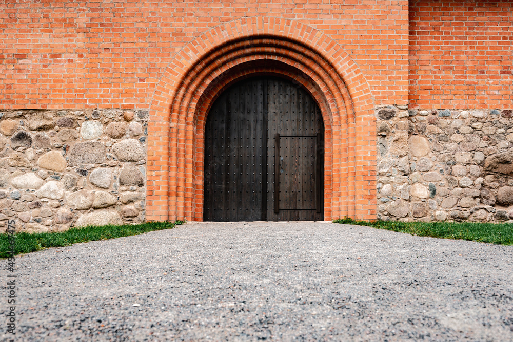 Wooden door in the castle of red bricks.
