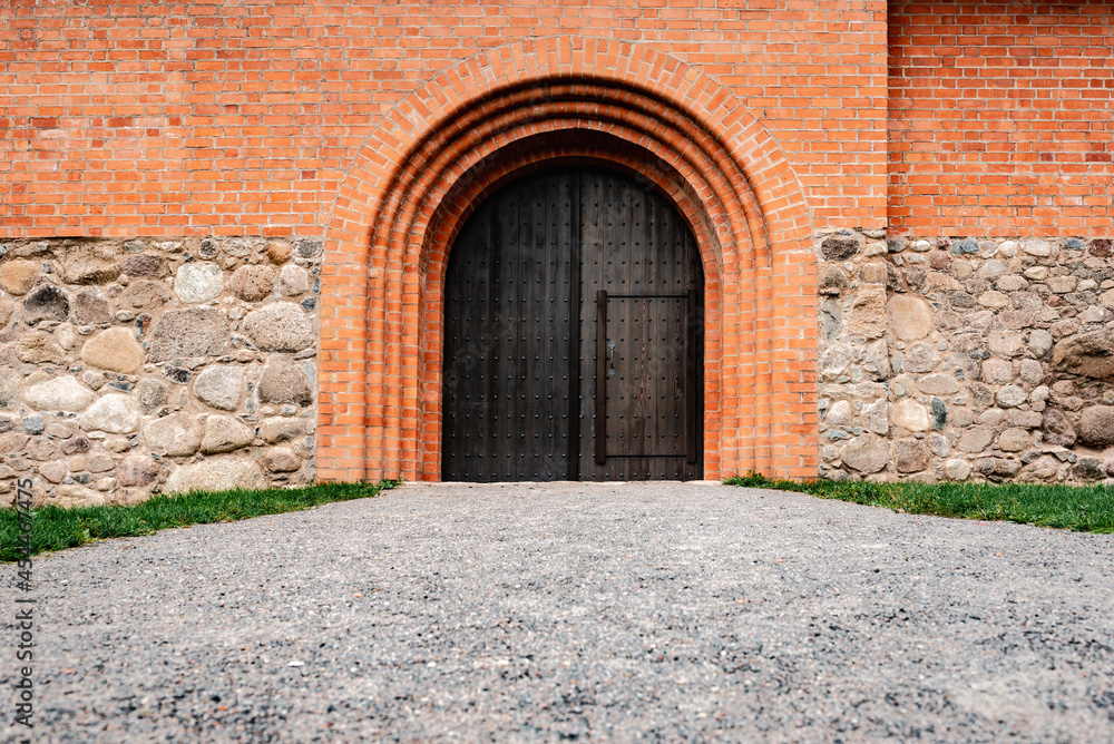 Fototapeta premium Wooden door in the castle of red bricks.