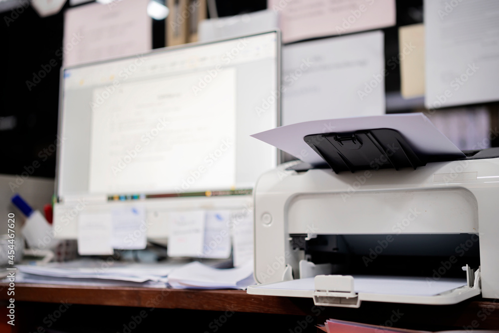 White printer in office with soft-focus and over light in the background. White printer in office with soft-focus and over light in the background.
