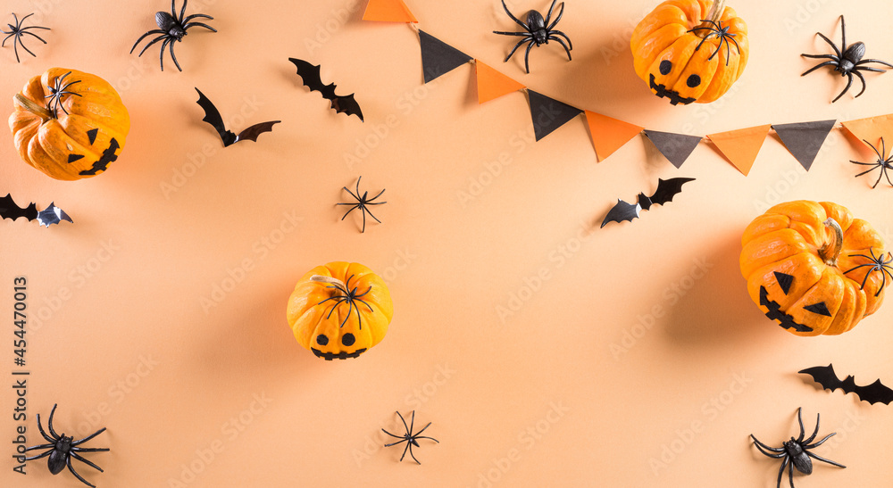 Top view of Halloween crafts, orange pumpkin, ghost, bat and black spider on pastel orange background. Flat lay, top view . Top view of Halloween crafts, orange pumpkin, ghost, bat and black spider on pastel orange background. Flat lay, top view .