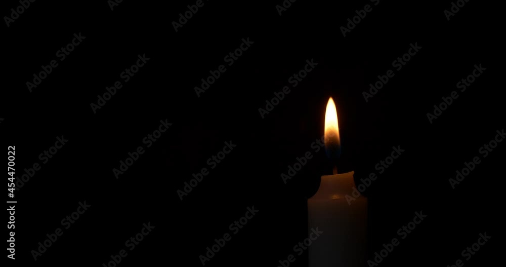 Close-up burning single candle flame isolated on black background, 4K video Close-up burning single candle flame isolated on black background, 4K video
