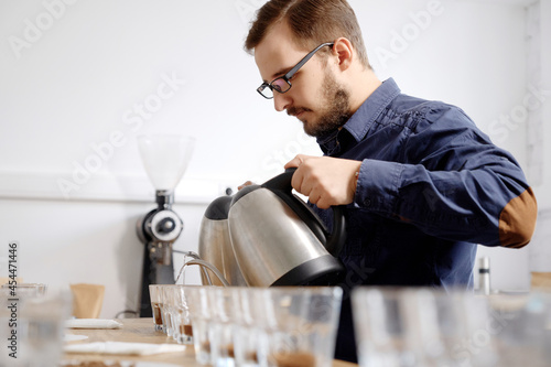 Barista pouring water to coffee cups