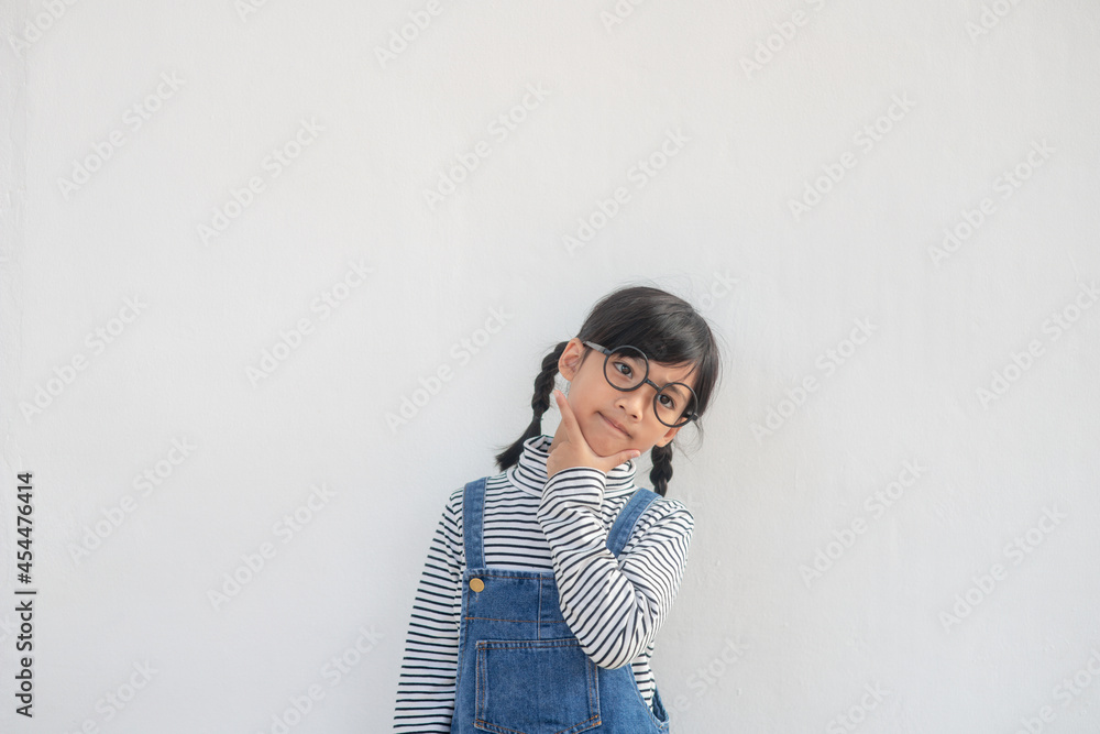 Cute Asian small girl wearing glasses and thinking Cute Asian small girl wearing glasses and thinking