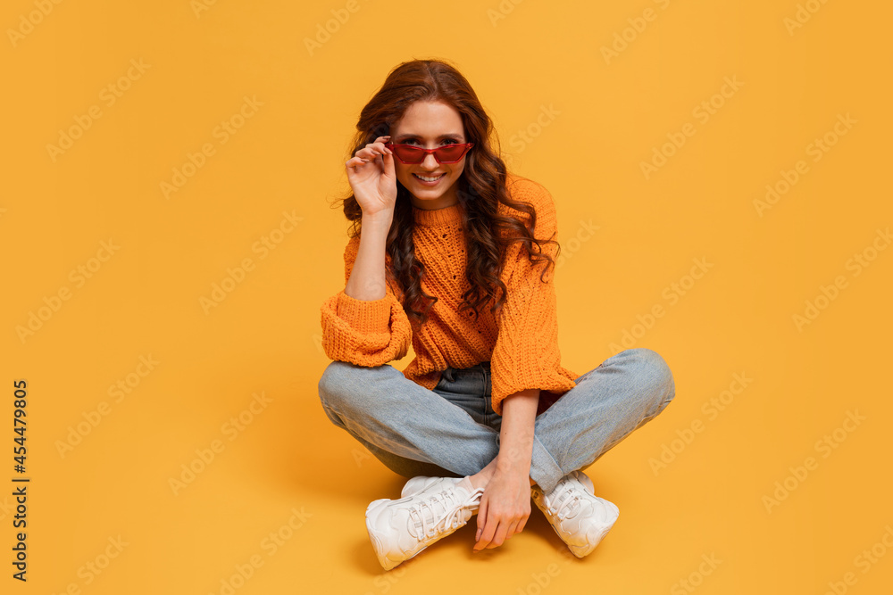 Pretty hipster red head girl in stylish autumn autfit posing over yellow background. Pretty hipster red head girl in stylish autumn autfit posing over yellow background.
