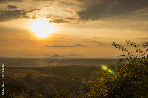 Golden sunrise in the mountains. Dawn in the mountains. The sun rises from behind the mountains. Beautiful green hills and green valley. Little sleeping town. Mountains in the fog. Carpathian, Ukraine