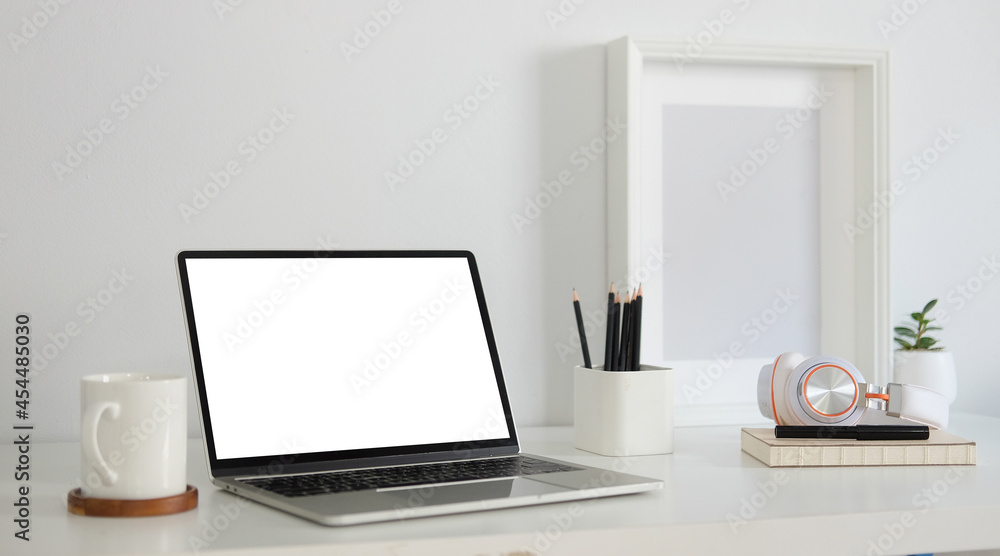 Mock up laptop computer, coffee cup, pencil holder and picture frame on white table. Mock up laptop computer, coffee cup, pencil holder and picture frame on white table.