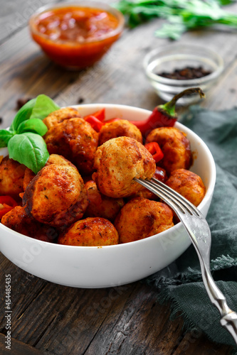 Chicken meatballs in a plate. Meatballs and basil. Copyspace. Wooden background