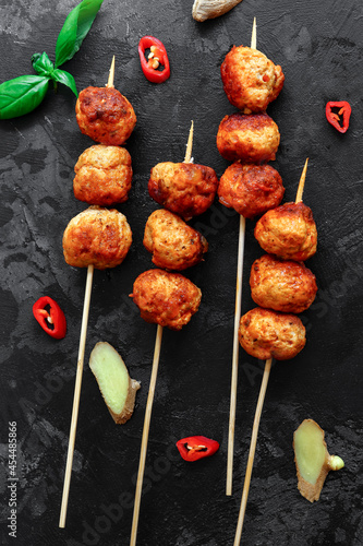 Chicken meatballs with basil Dark background. Copyspace. Meatballs on a wooden skewer