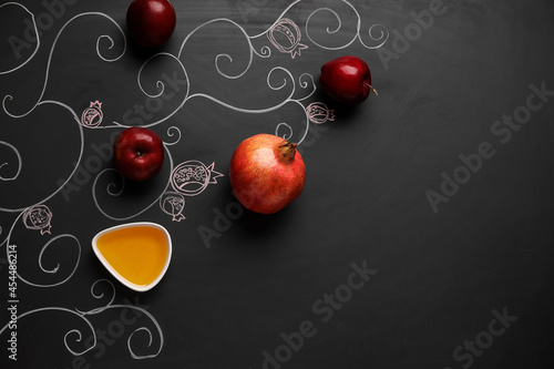 Honey with fruits on dark background. Rosh hashanah (Jewish New Year) celebration