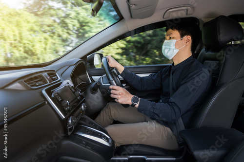 man in medical mask driving a car. for protect covid-19 (coronavirus) © geargodz