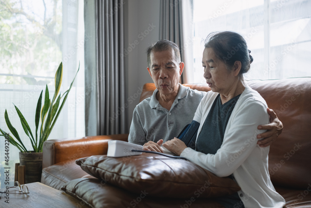 Asian senior couple checking blood pressure at home, after the blood pressure gauge shows the result they shocked. Asian senior couple checking blood pressure at home, after the blood pressure gauge shows the result they shocked.