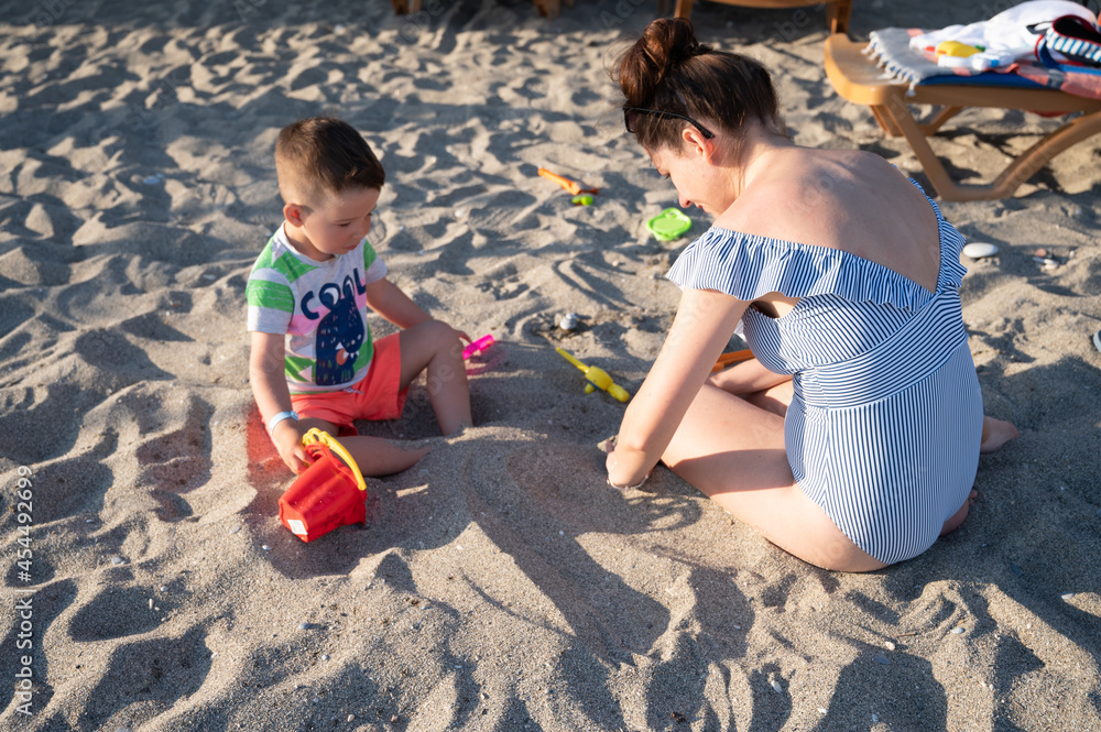Fototapeta premium Mom on vacation with her baby on the beach