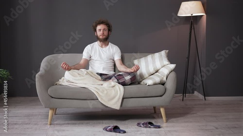 Yoga Meditation Before Bedtime. Happy Young Yogi Man Sits in a Lotus Position Home. High quality 4k footage. photo