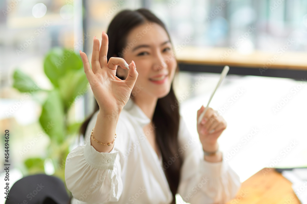 Asian young businesswoman making OK hand sign, happy, satisfied Asian young businesswoman making OK hand sign, happy, satisfied